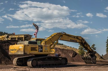 A man performing a handstand on a bulldozer at a construction site in Truckee, CA.